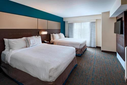 a hotel room with two beds and a television at Residence Inn by Marriott Omaha West in Omaha