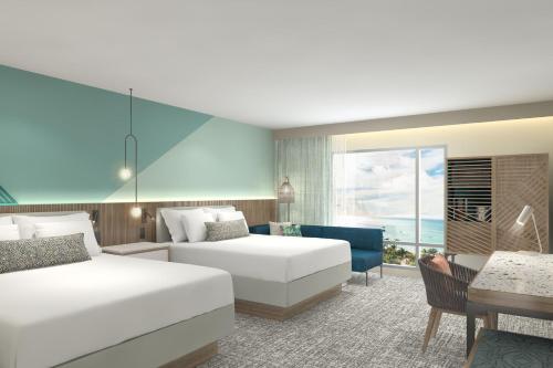 une chambre d'hôtel avec deux lits et un canapé dans l'établissement Courtyard by Marriott Curacao, à Willemstad