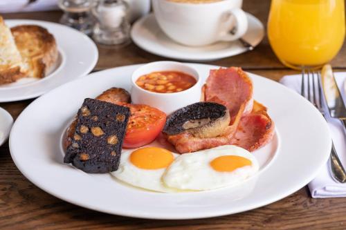 a plate of breakfast food on a wooden table at The Coach and Horses in Clitheroe