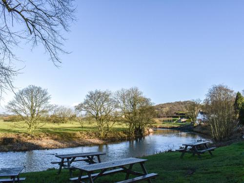 three picnic tables in a park next to a river at Burnsall Cottage - Uk43254 in Airton
