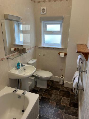 uma casa de banho branca com um lavatório e um WC em Ocean View em Ilfracombe
