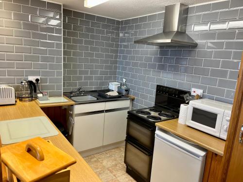 a kitchen with a stove and a microwave at Ocean View in Ilfracombe