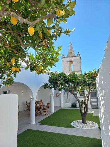 a courtyard with an orange tree and a church at Casa Dona Antonia - Monsaraz in Monsaraz