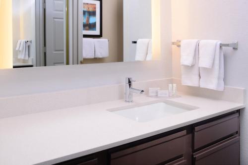 a bathroom with a white sink and a mirror at Residence Inn by Marriott Dallas Plano/Legacy in Plano