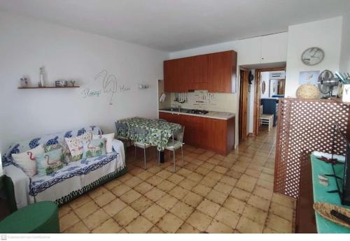 una cucina e un soggiorno con divano e tavolo di Casa Flamingo House a San Teodoro