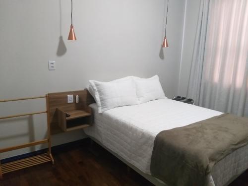 um pequeno quarto com uma cama e uma mesa de cabeceira em A3EM Casa de Gorceix em Ouro Preto