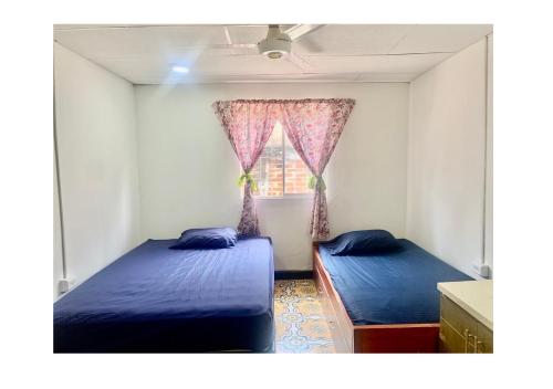 1 dormitorio con 2 camas y ventana en Casa Cairo, en Cartagena de Indias