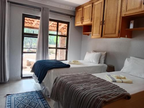 2 camas en una habitación con ventana en Nakhah Guesthouse - Double Room en Witbank