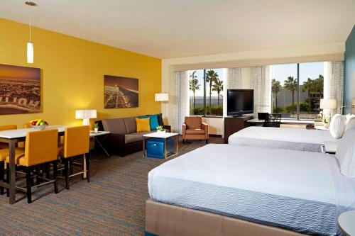 a hotel room with two beds and a living room at Residence Inn by Marriott Los Angeles LAX/Century Boulevard in Los Angeles