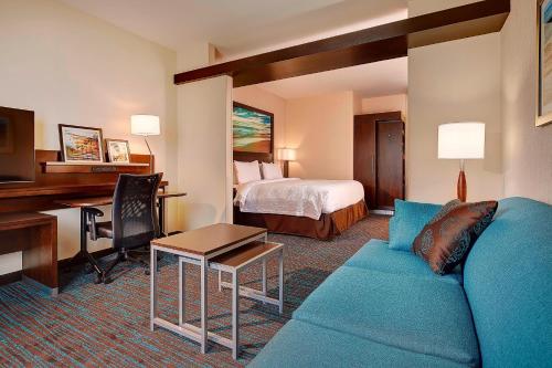 Habitación de hotel con sofá, cama y escritorio. en Fairfield Inn & Suites by Marriott San Diego Carlsbad, en Carlsbad