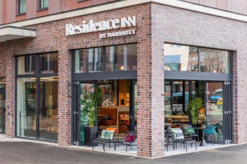 ein Backsteingebäude mit Tischen und Stühlen am Fenster in der Unterkunft Residence Inn by Marriott Dortmund City in Dortmund