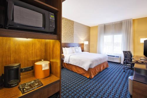 a hotel room with a bed and a flat screen tv at Fairfield Inn & Suites by Marriott Plattsburgh in Plattsburgh