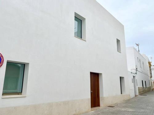 a white building with a wooden door on a street at IDEAL ESTUDIO PARA PAREJAS in Conil de la Frontera