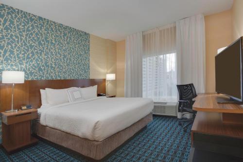 a hotel room with a bed and a flat screen tv at Fairfield Inn & Suites By Marriott Fort Lauderdale Downtown/Las Olas in Fort Lauderdale
