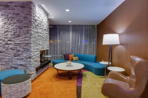 a living room with a blue couch and a stone wall at Fairfield Inn & Suites By Marriott Fort Lauderdale Downtown/Las Olas in Fort Lauderdale