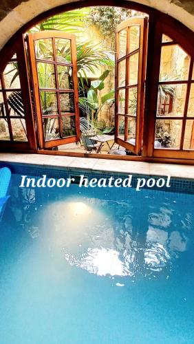 アーブにあるIl Mithna farmhouse with indoor heated jacuzzi poolの温水プールの近くに位置し、窓が付いています。