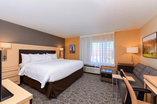 Habitación de hotel con cama y sofá en TownePlace by Marriott Suites Detroit Auburn Hills, en Auburn Hills