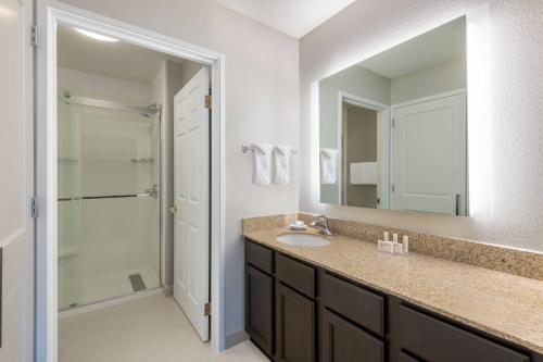 a bathroom with a sink and a mirror and a shower at Residence Inn Indianapolis Downtown on the Canal in Indianapolis