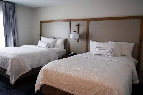 Habitación de hotel con 2 camas con sábanas blancas en Fairfield by Marriott Youngstown/Austintown en Youngstown