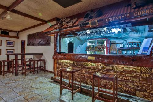 a bar with wooden stools and a counter in a room at Hotel Kununurra in Kununurra