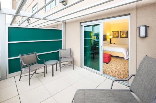 Houston Marriott Energy Corridor في هيوستن: غرفة بغرفة نوم وسرير وطاولة وكراسي