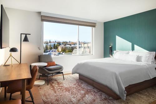 a bedroom with a bed and a desk and a window at Element Reno Experience District in Reno