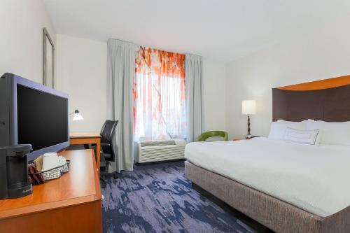a hotel room with a bed and a flat screen tv at Fairfield Inn & Suites by Marriott Mahwah in Mahwah