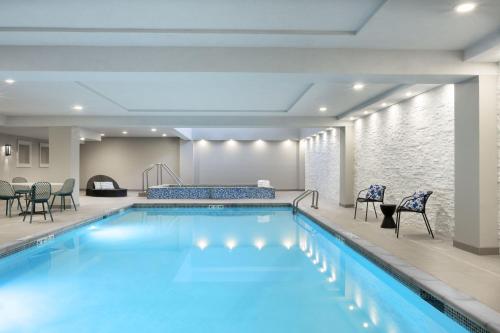 einen Pool in einem Hotelzimmer mit Stühlen und Tischen in der Unterkunft The Warrior Hotel, Autograph Collection in Sioux City