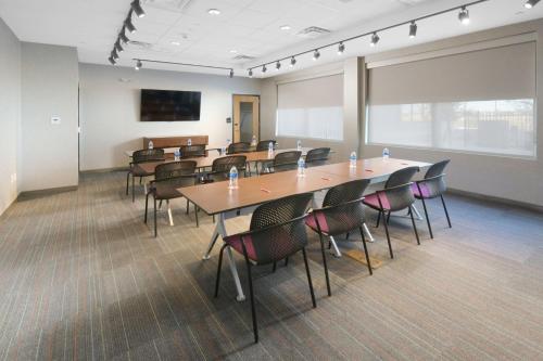a conference room with tables and chairs and a screen at Aloft Lubbock in Lubbock