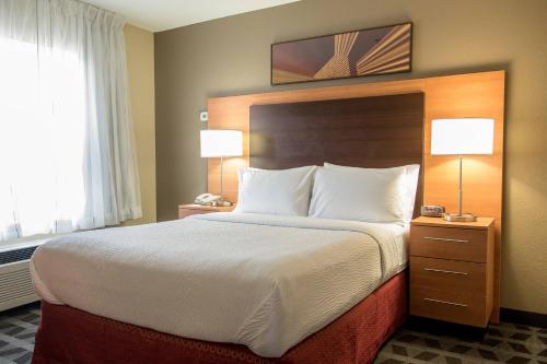 a large bed in a hotel room with two lamps at TownePlace Suites by Marriott Lafayette in Lafayette