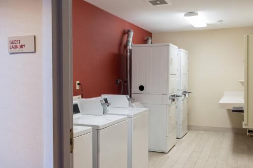 a laundry room with white appliances and a red wall at TownePlace Suites by Marriott Lafayette in Lafayette