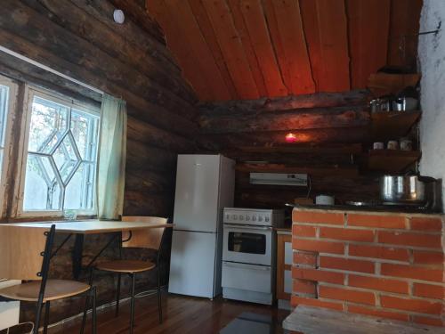 a kitchen with a refrigerator and a table and a brick wall at Log Cabin - Lord of Sormuset in Inari