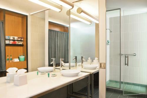 a bathroom with three sinks and a shower at Aloft Richmond West Short Pump in Short Pump