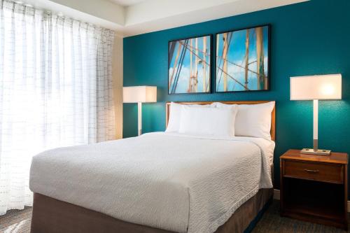 a bedroom with a large bed and a blue wall at Residence Inn San Diego Sorrento Mesa/Sorrento Valley in Sorrento