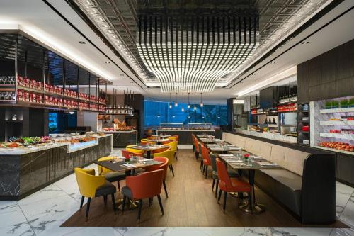 a restaurant with tables and chairs and a buffet at Renaissance Kuala Lumpur Hotel & Convention Centre in Kuala Lumpur