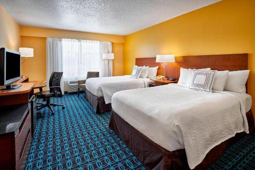 Habitación de hotel con 2 camas, escritorio y TV. en Fairfield Inn Myrtle Beach Broadway at the Beach en Myrtle Beach