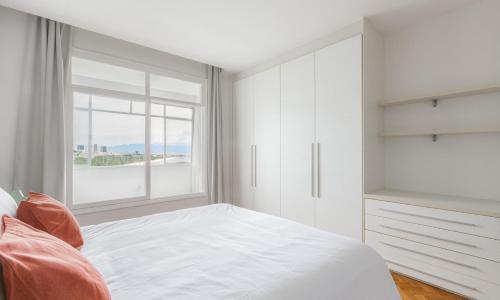um quarto branco com uma cama e uma janela em Tabas Maravilhoso apê no Flamengo FL0003 no Rio de Janeiro