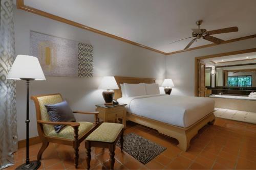 マイカオビーチにあるMarriott's Phuket Beach Clubのベッドルーム1室(ベッド1台、椅子、鏡付)