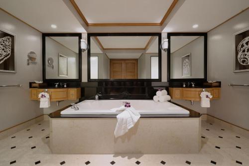 a large bathroom with a tub and a large mirror at Marriott's Phuket Beach Club in Mai Khao Beach