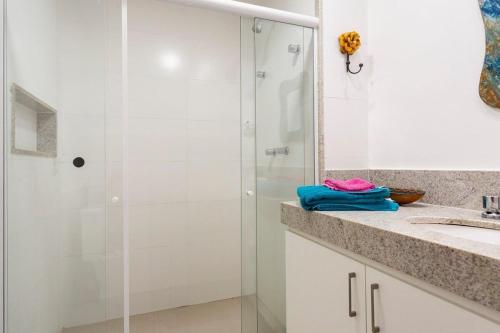 a bathroom with a shower and a sink at Apto Itaipava, piscina borda infinita, montanha in Itaipava