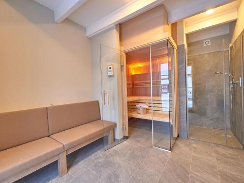a bathroom with a bench and a shower at Ferienhäuser im Torfhaus Harzresort, Torfhaus in Torfhaus