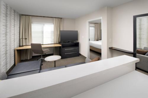 a hotel room with a desk and a tv at Residence Inn by Marriott Modesto North in Modesto