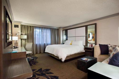 リトルロックにあるLittle Rock Marriottのベッドとソファ付きの広いホテルルームです。