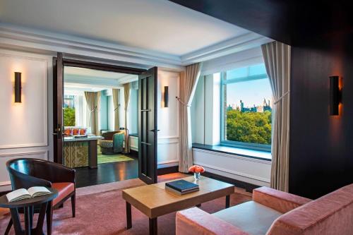 a living room with a couch and a table and a window at The Ritz-Carlton New York, Central Park in New York
