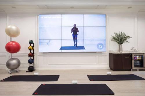 a room with a large screen with a person on it at The Ritz-Carlton New York, Central Park in New York