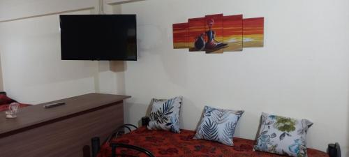 a room with a bed with pillows and a tv at Departamento Alicia in General Roca