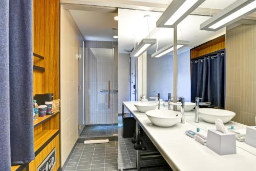 a bathroom with three sinks and a shower at Aloft Phoenix Airport in Phoenix