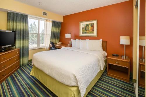 a hotel room with a bed and a flat screen tv at Residence Inn Spokane East Valley in Spokane Valley