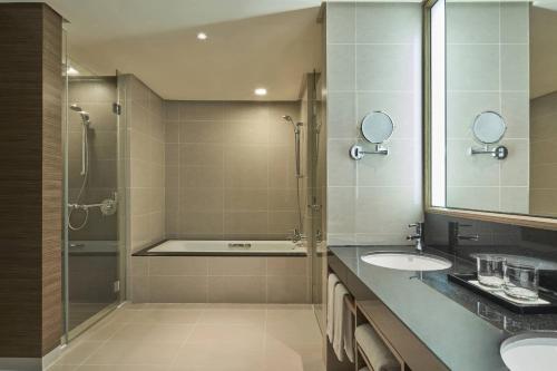 a bathroom with two sinks and a shower at Renaissance Johor Bahru Hotel in Johor Bahru