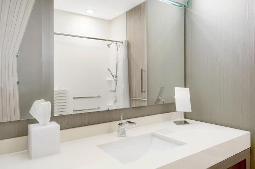 a white bathroom with a sink and a mirror at Courtyard by Marriott Longview North in Longview